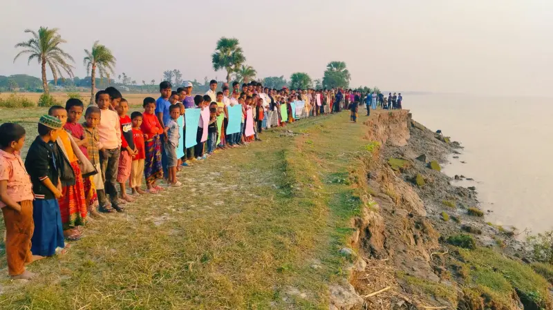 হাতিয়ায় নদীর তীরে দাঁড়িয়ে ভাঙ্গন রক্ষায় মানববন্ধন